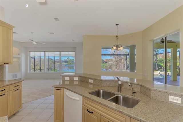 kitchen with light carpet, light stone countertops, sink, and light brown cabinetry