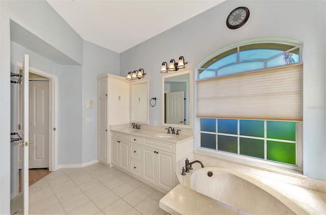 bathroom featuring vanity, a washtub, and tile patterned flooring