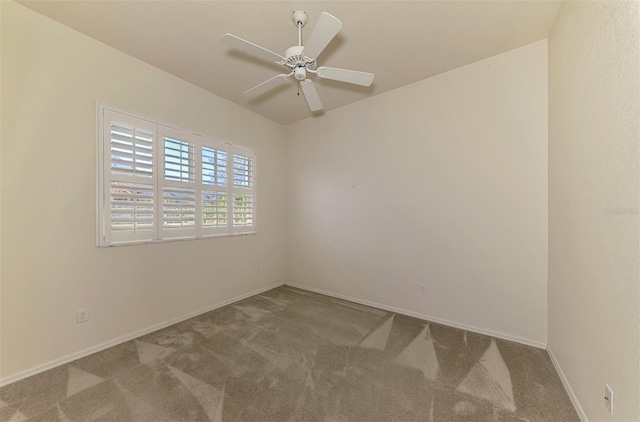 carpeted spare room with ceiling fan