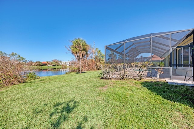 view of yard featuring a water view and glass enclosure