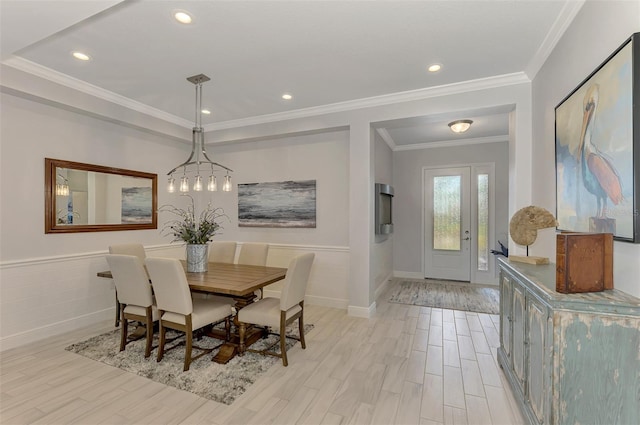 dining space featuring crown molding, a notable chandelier, and light hardwood / wood-style flooring