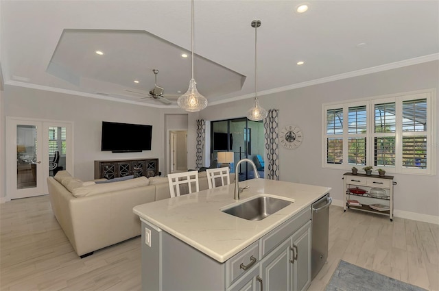 kitchen with a healthy amount of sunlight, sink, stainless steel dishwasher, and a center island with sink