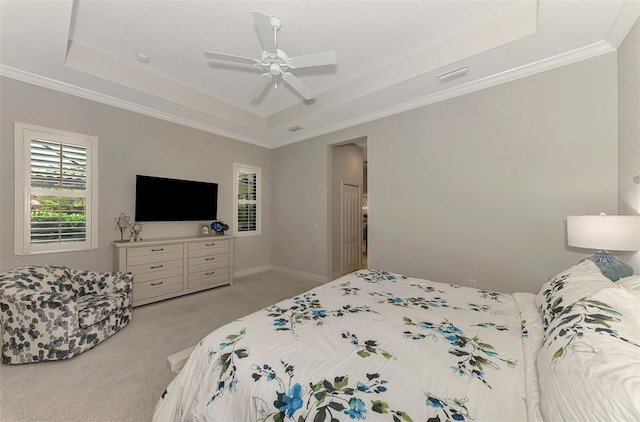 bedroom featuring light carpet, crown molding, a raised ceiling, and ceiling fan