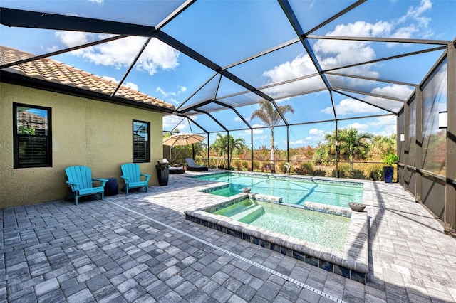 view of swimming pool with a patio, an in ground hot tub, and glass enclosure