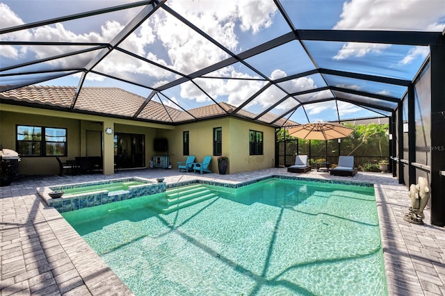 view of pool featuring a patio area, a lanai, and an in ground hot tub