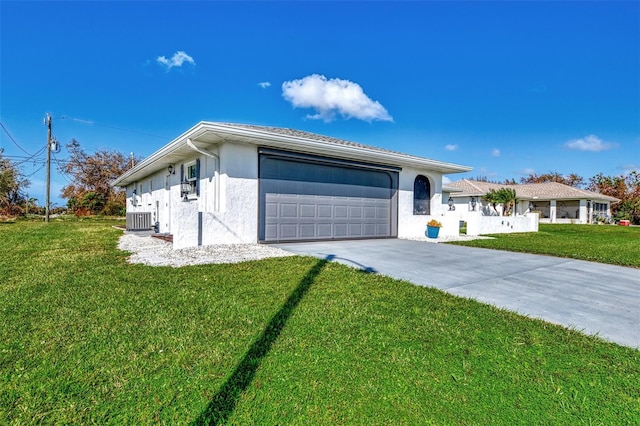 ranch-style house featuring a front yard, a garage, and central AC unit