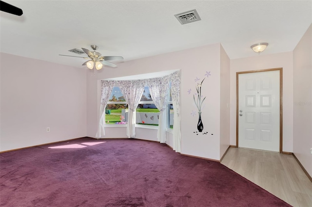 carpeted foyer with ceiling fan