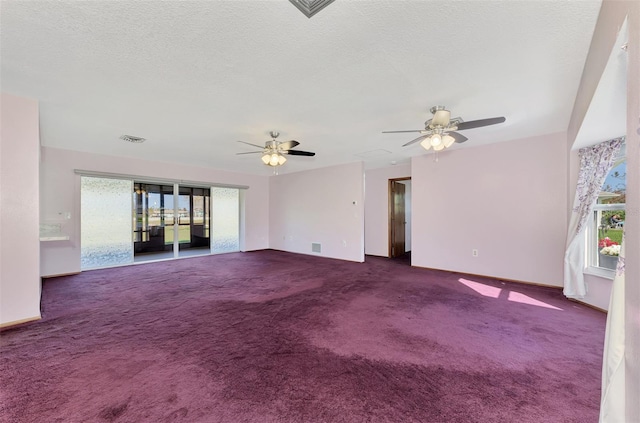 interior space featuring dark colored carpet, a textured ceiling, and ceiling fan