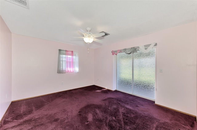 empty room with dark carpet and ceiling fan