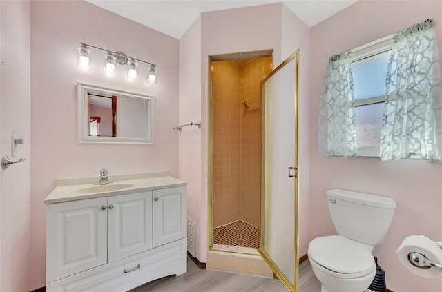 bathroom featuring toilet, an enclosed shower, hardwood / wood-style flooring, and vanity