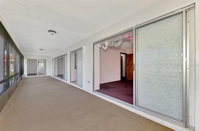 hallway with a textured ceiling and carpet floors