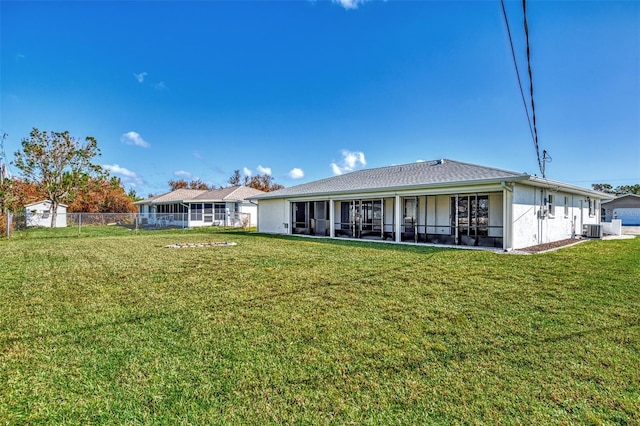 back of house featuring a patio, a sunroom, central air condition unit, and a lawn