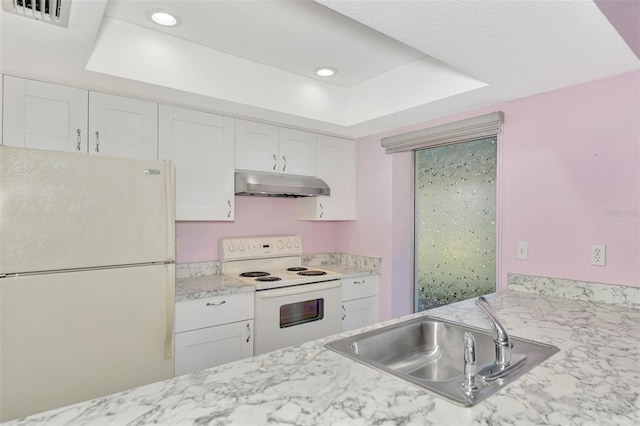 kitchen with a tray ceiling, sink, white appliances, and white cabinets