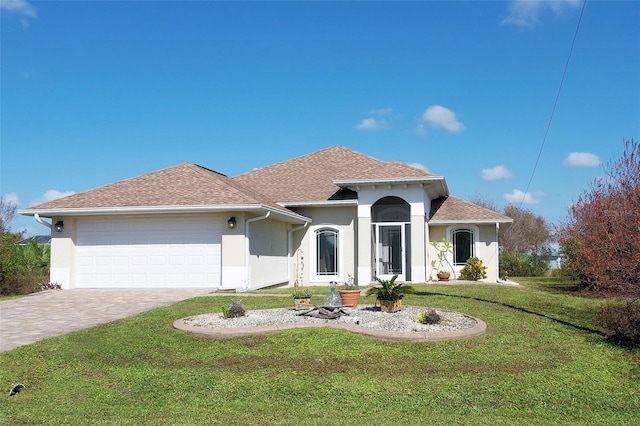 mediterranean / spanish-style house featuring a front yard and a garage