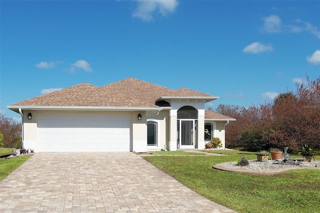 mediterranean / spanish-style house featuring a front yard and a garage