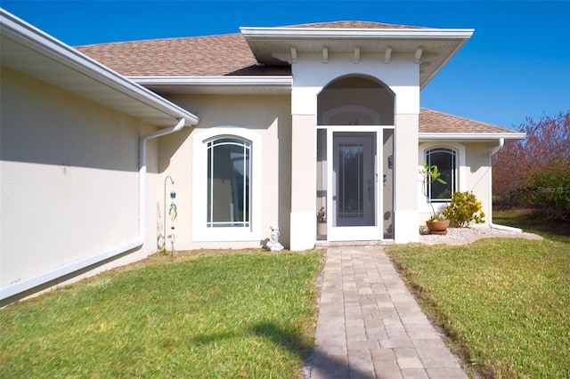 entrance to property featuring a lawn