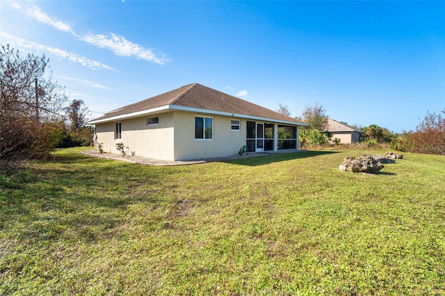 back of property with a sunroom and a lawn