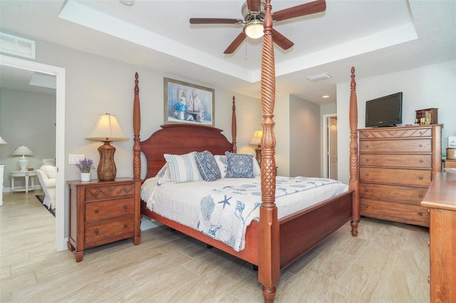 bedroom with a tray ceiling and ceiling fan