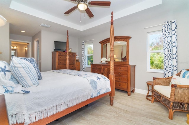 bedroom with a tray ceiling and ceiling fan