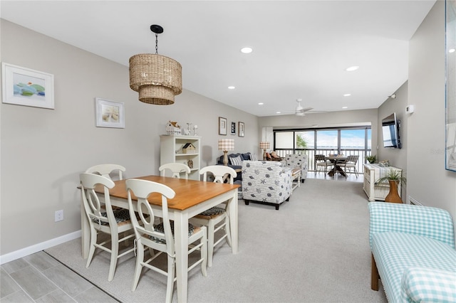 carpeted dining room with ceiling fan