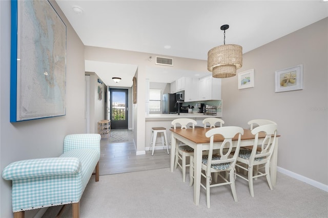 dining space with sink and light hardwood / wood-style floors