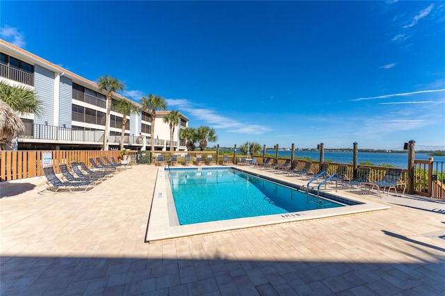 view of pool featuring a patio area and a water view