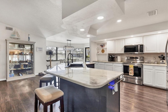 kitchen featuring sink, an island with sink, hanging light fixtures, and appliances with stainless steel finishes