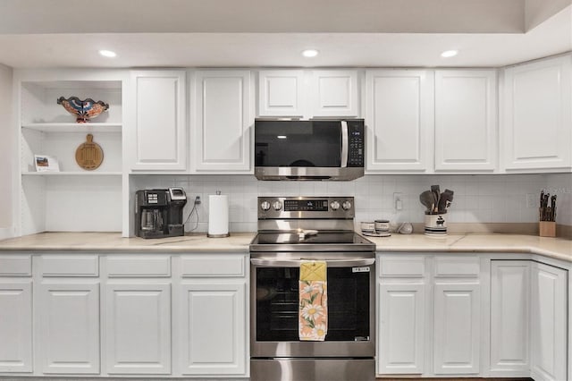 kitchen with tasteful backsplash, white cabinets, and stainless steel appliances