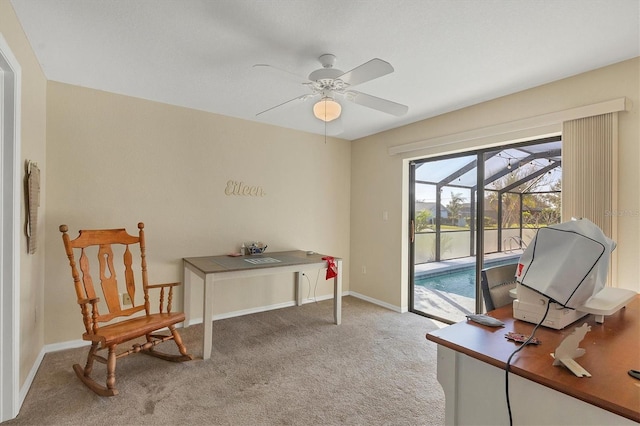 carpeted home office featuring ceiling fan