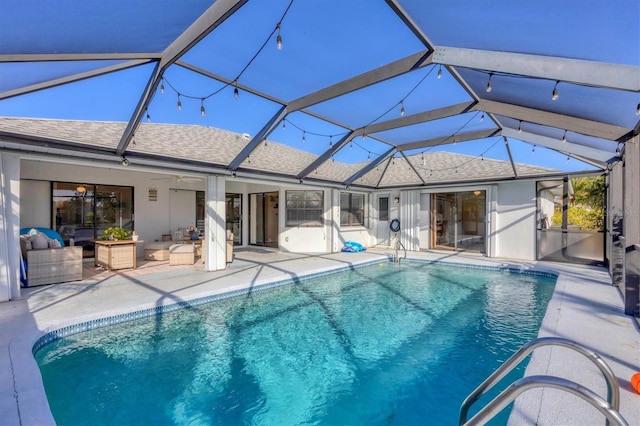 view of pool featuring glass enclosure, ceiling fan, and a patio area