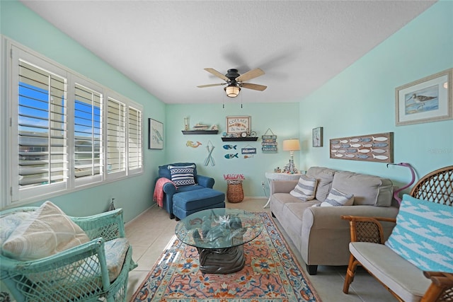 living room featuring ceiling fan, a textured ceiling, and light tile patterned floors