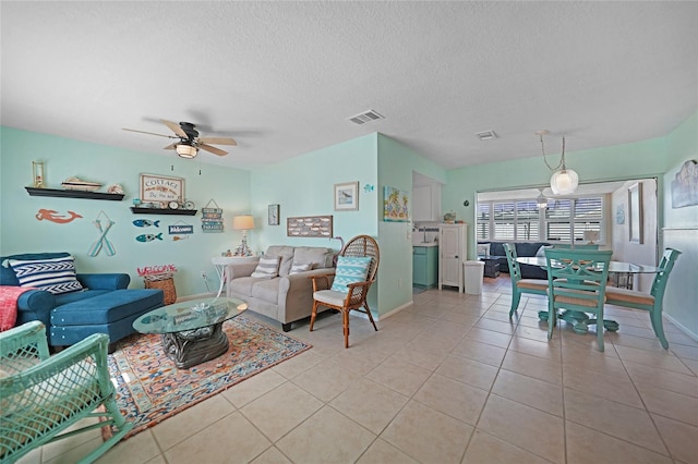 tiled living room featuring a textured ceiling and ceiling fan