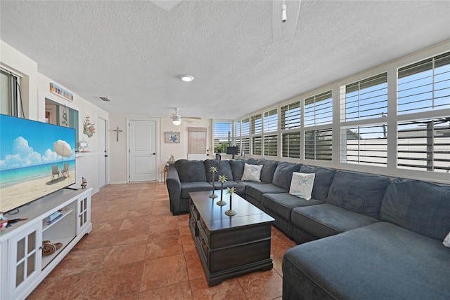 living room featuring ceiling fan and a textured ceiling