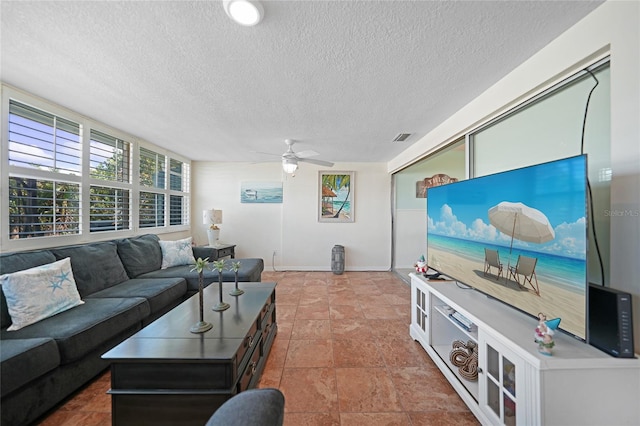 living room with ceiling fan and a textured ceiling