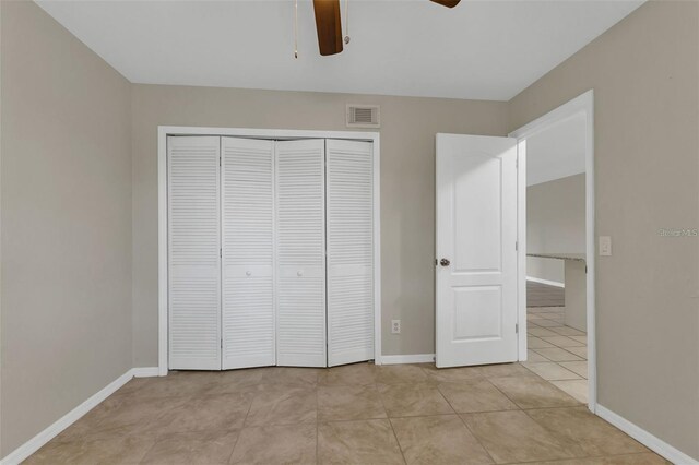 unfurnished bedroom with a closet, ceiling fan, and light tile patterned floors