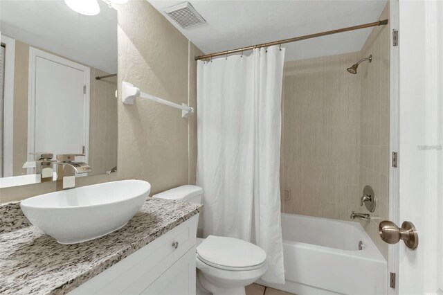 full bathroom featuring vanity, shower / tub combo with curtain, and toilet