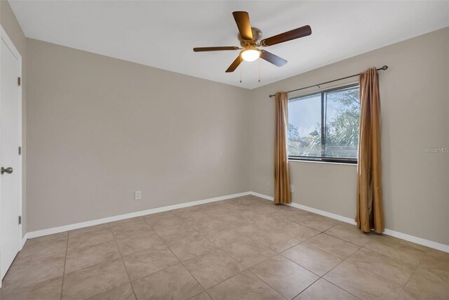 spare room featuring ceiling fan and light tile patterned flooring