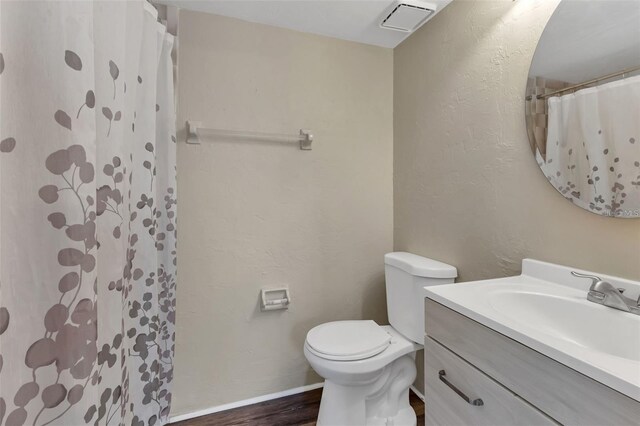 bathroom with vanity, toilet, hardwood / wood-style flooring, and curtained shower