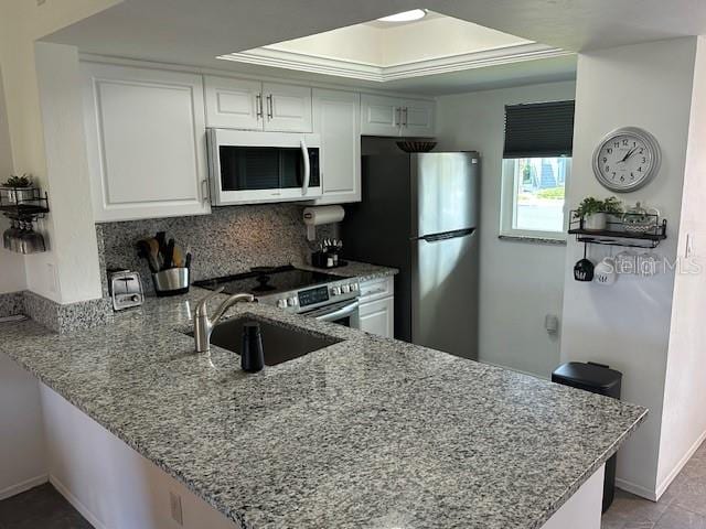 kitchen featuring white cabinetry, sink, kitchen peninsula, and stainless steel appliances