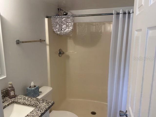 bathroom with vanity, toilet, and walk in shower