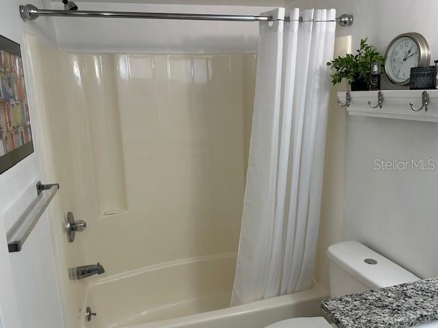 bathroom featuring shower / bath combo and toilet