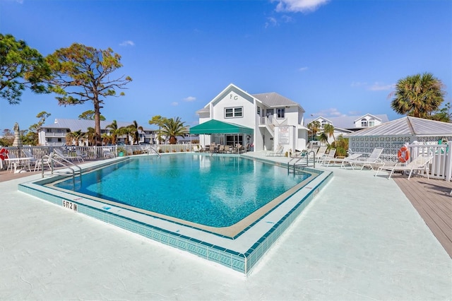 community pool featuring fence and a patio