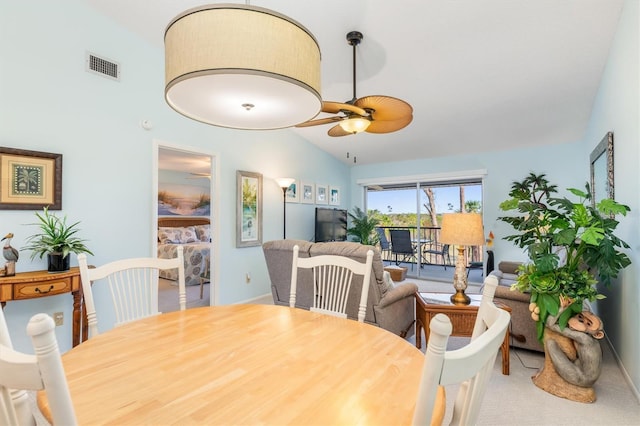 carpeted dining room featuring vaulted ceiling and ceiling fan