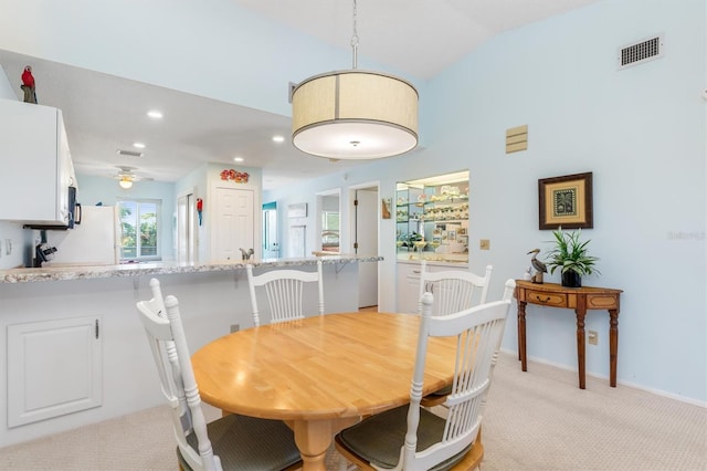 dining room featuring visible vents, baseboards, light colored carpet, lofted ceiling, and recessed lighting