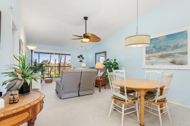 carpeted dining room with ceiling fan and vaulted ceiling