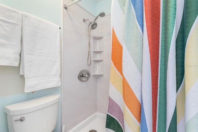 bathroom featuring a shower with curtain and toilet