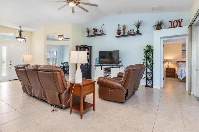 tiled living room with ceiling fan, plenty of natural light, and lofted ceiling