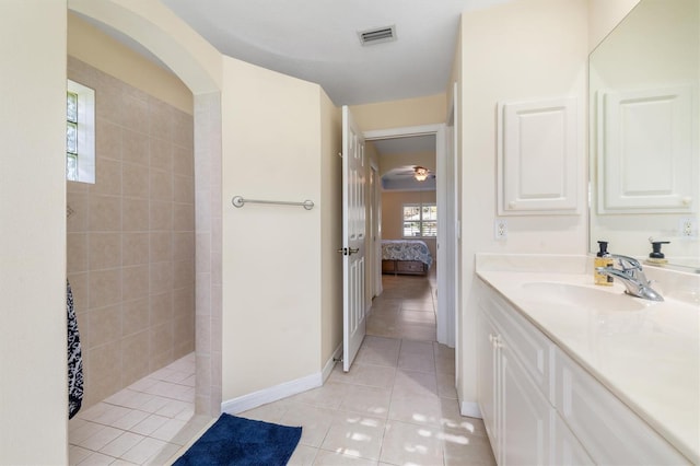 bathroom featuring tiled shower, vanity, and tile patterned floors