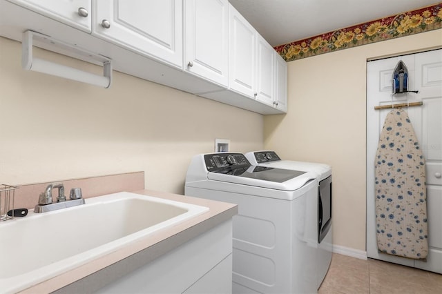 laundry room with cabinets, light tile patterned floors, washing machine and dryer, and sink