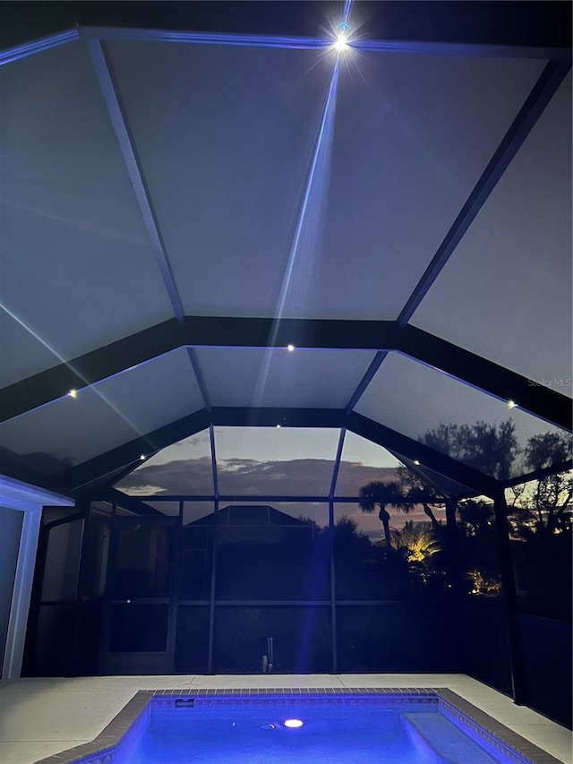 view of swimming pool featuring glass enclosure